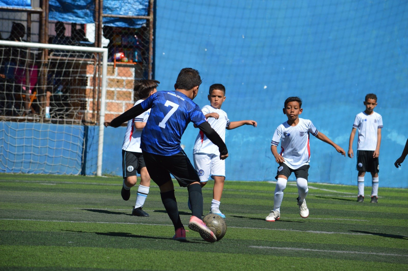 Aluno avançando com a bola durante o jogo