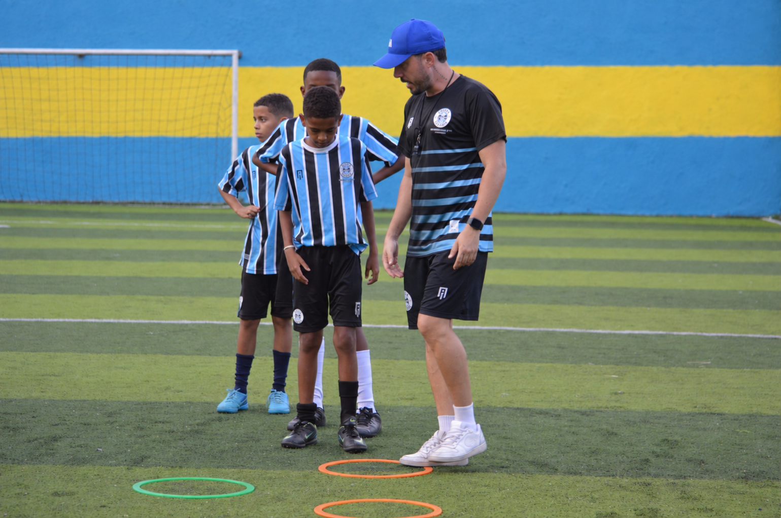 Professor orientando crianças durante o treino