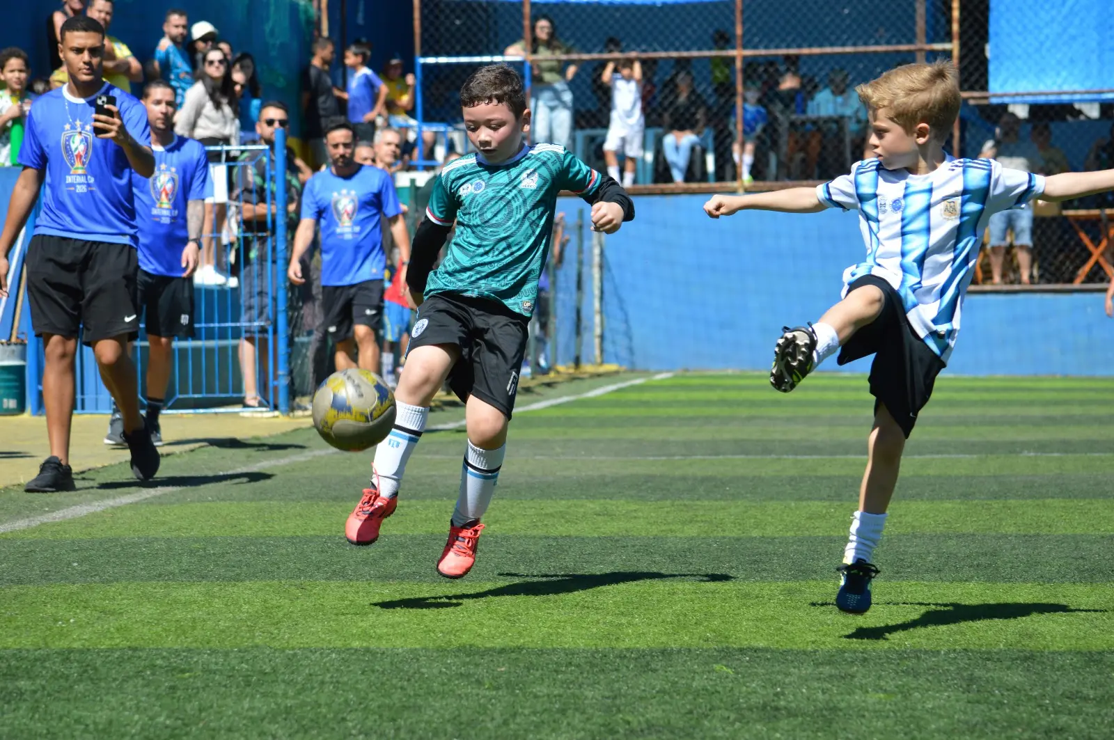 Crianças em uma disputa de bola durante a partida